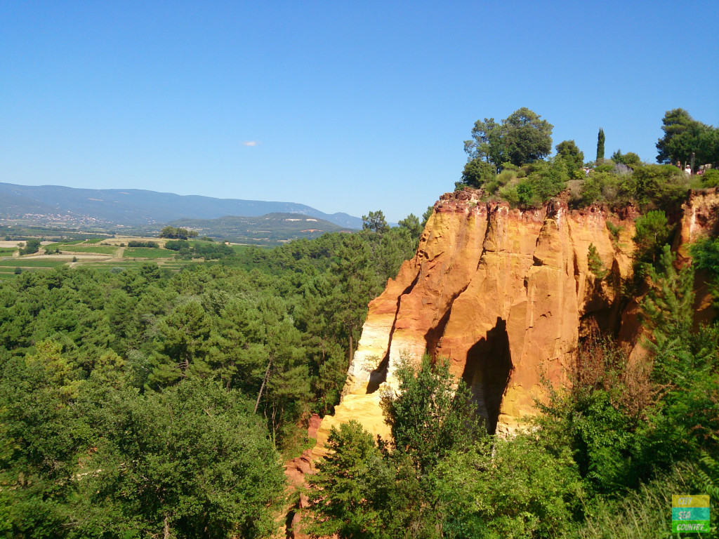Blick vom Zentrum von Roussillon auf die orangefarbenen berühmten Ockerfelsen der Provence