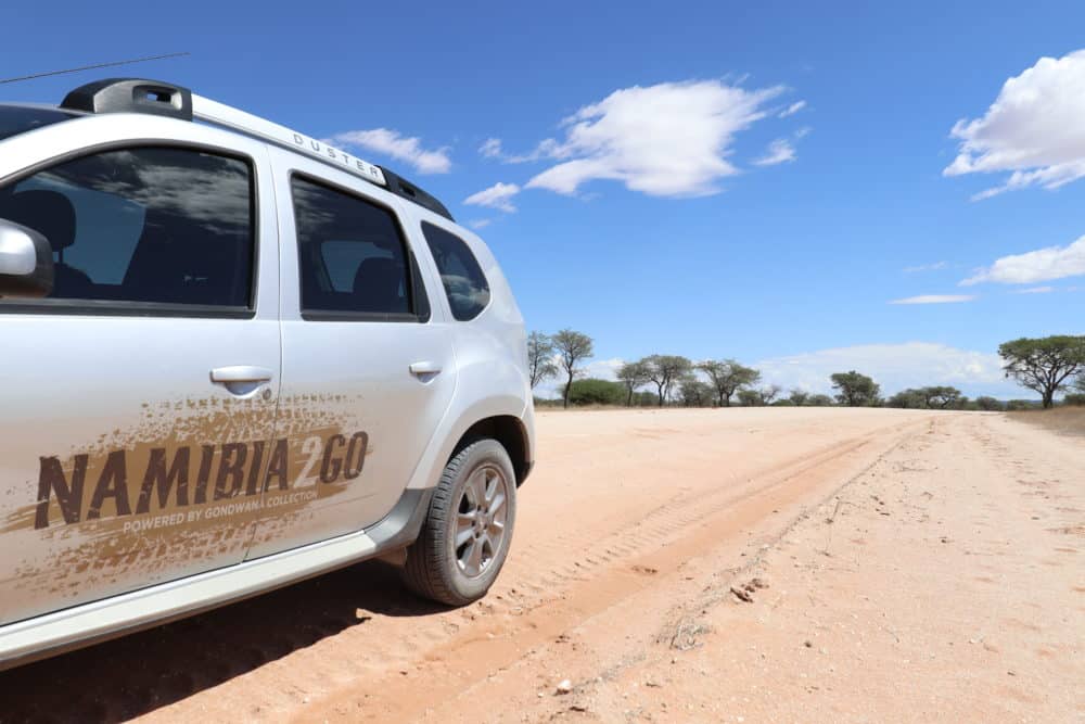 Ein SUV mit Allrad auf einer Sand- und Schotterstraße in Namibia.