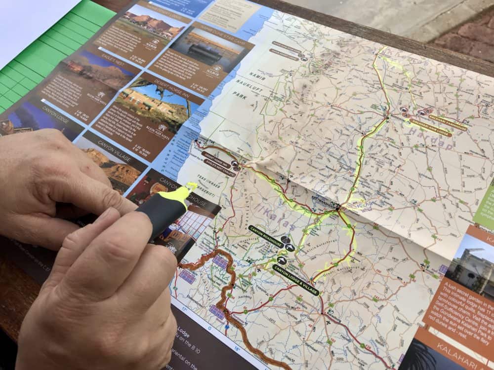 Reiseplanung mit Hilfe einer Straßenkarte von Namibia. Die Route wird hier mit einem Leuchtstift markiert.