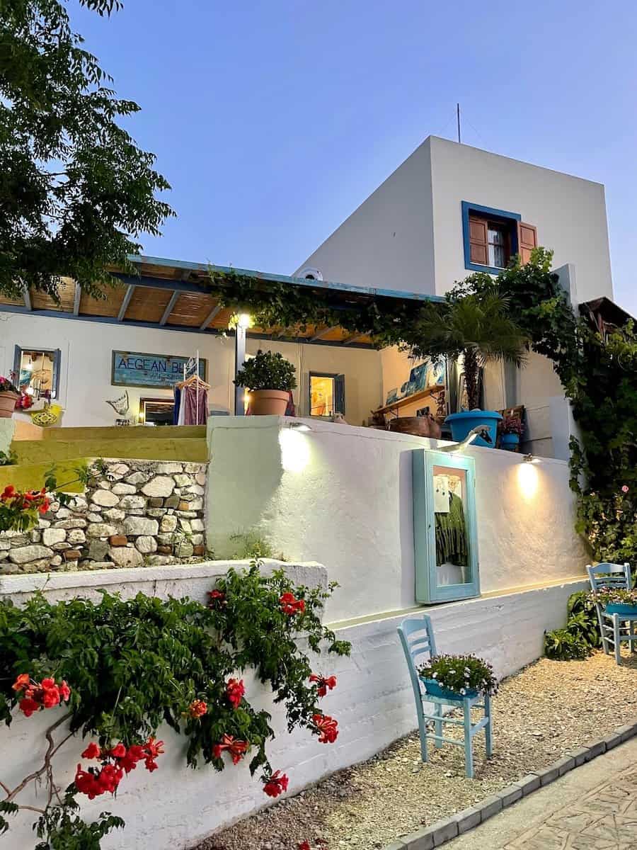 abendliche Stimmung im Berdorf Zia mit Blick auf ein weiß getünchtes Haus mit Blumenschmuck