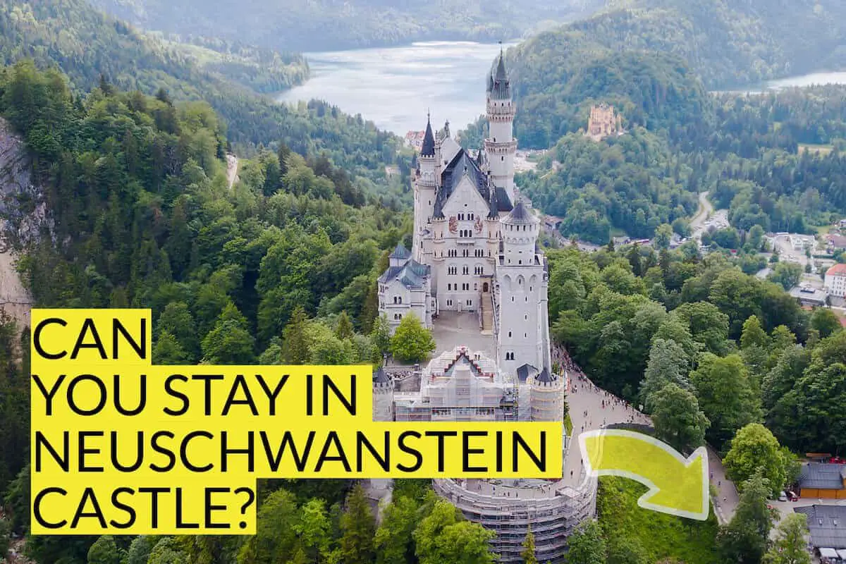 aerial view of neuschwanstein castle with text can you stay in neuschwanstein castle