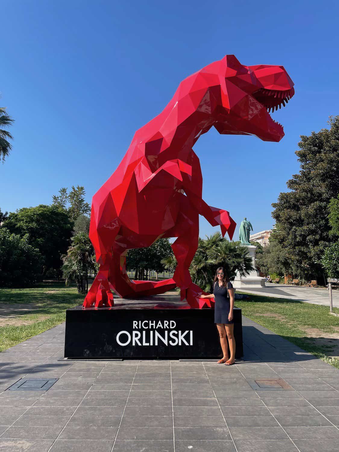 Reiseexpertin Christina vor einem roten Tyrannosaurus Rex des Künstlers Richard Orlinski am Parc & Jardins de Nice