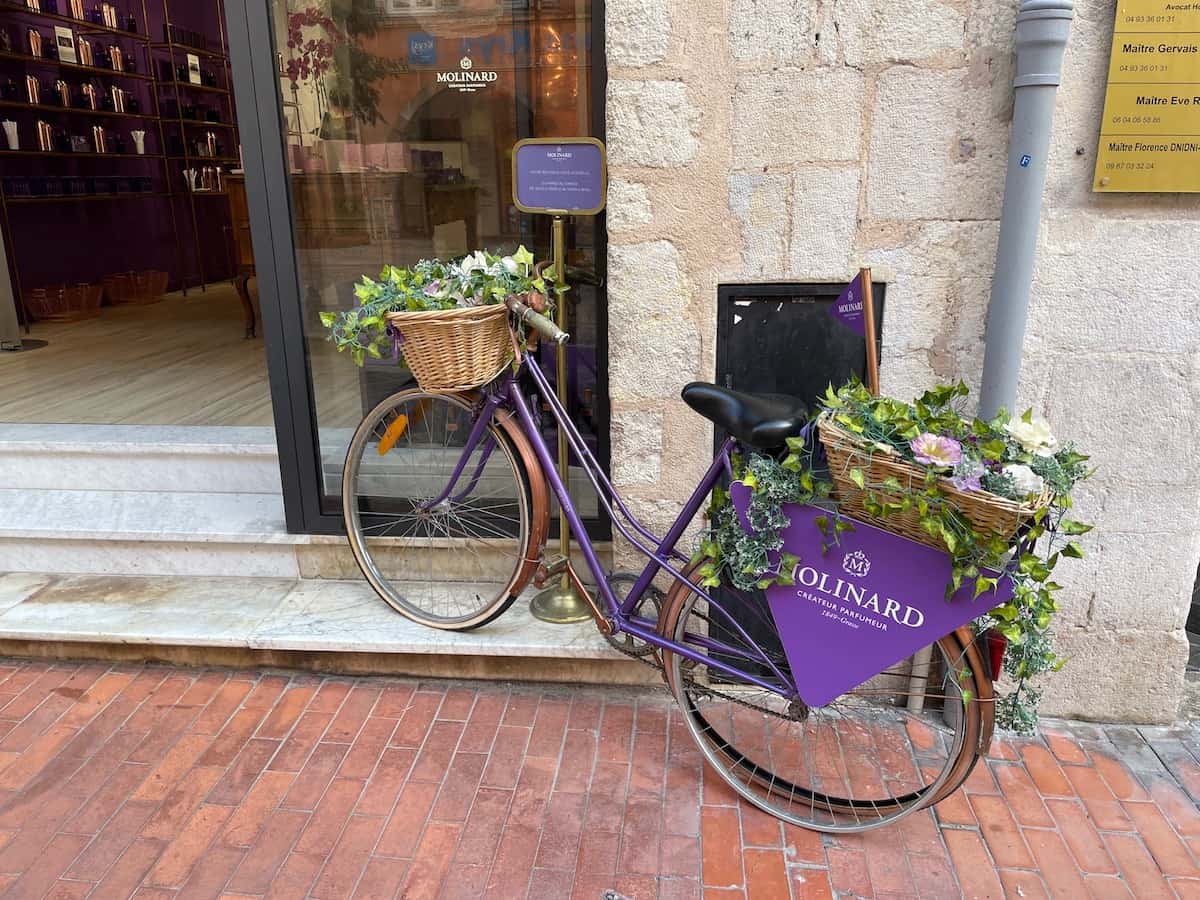 dekoriertes Fahrrad vor Schaufenster der Parfümerie Molinard in Grasse