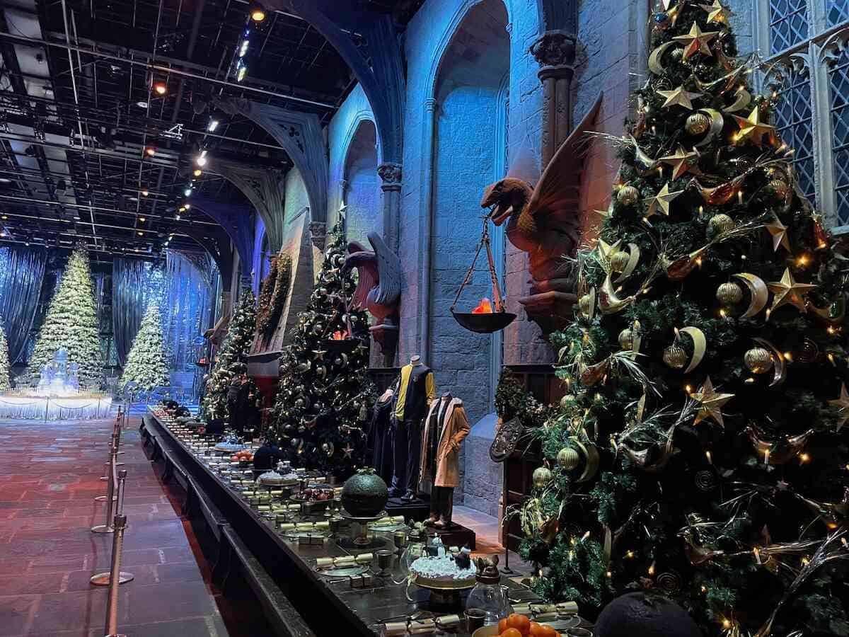 Große Halle von Hogwarts im winterlichen Zauber mit schneebedeckten Tannen und festlichen Weihnachtsbäumen, eine magische Harry Potter Sehenswürdigkeit.