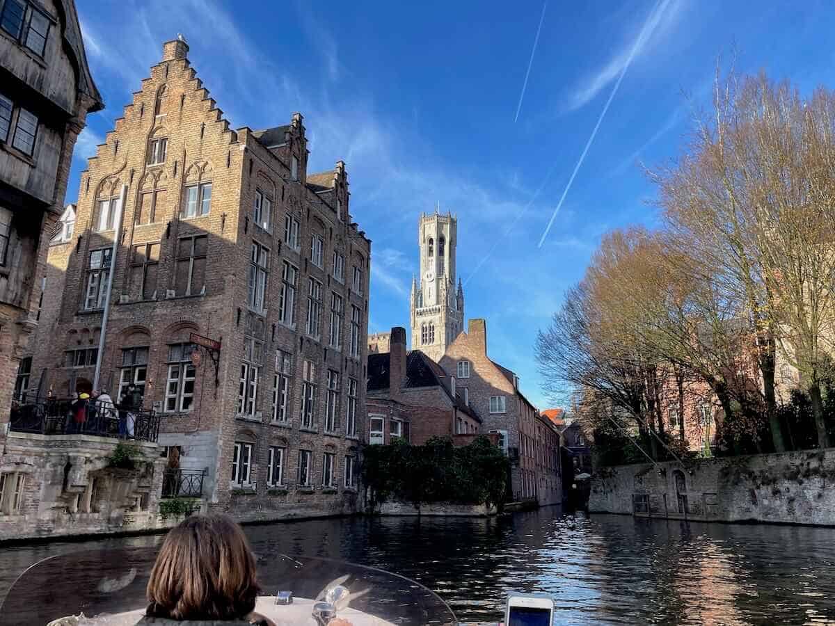 View from a boat during a boat tour in Bruges with the Belfort in the background.