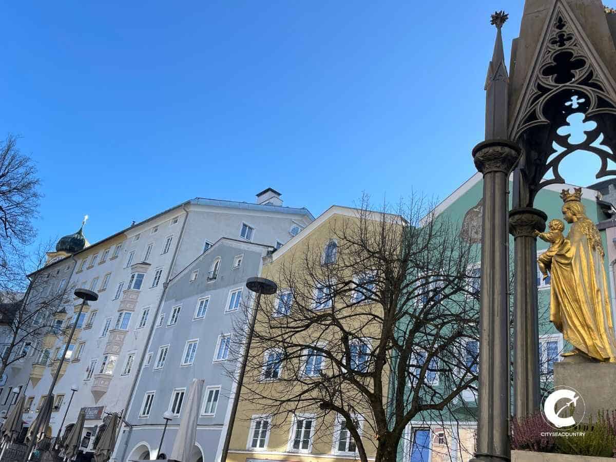 Blick auf den Marienbrunnen und die bunten Häuserfronten am Unteren Stadtplatz in Kufstein