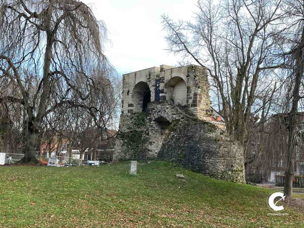 Blick auf den Rest der Stadtmauer im Donatuspark im Dezember mit kahler Trauerweide