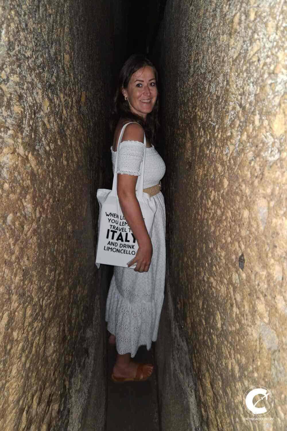 Autorin Christina von cityseacountry.com in einem 35 cm schmalen, 80 m langen, dunklen Tunnel im Untergrund von Neapel.