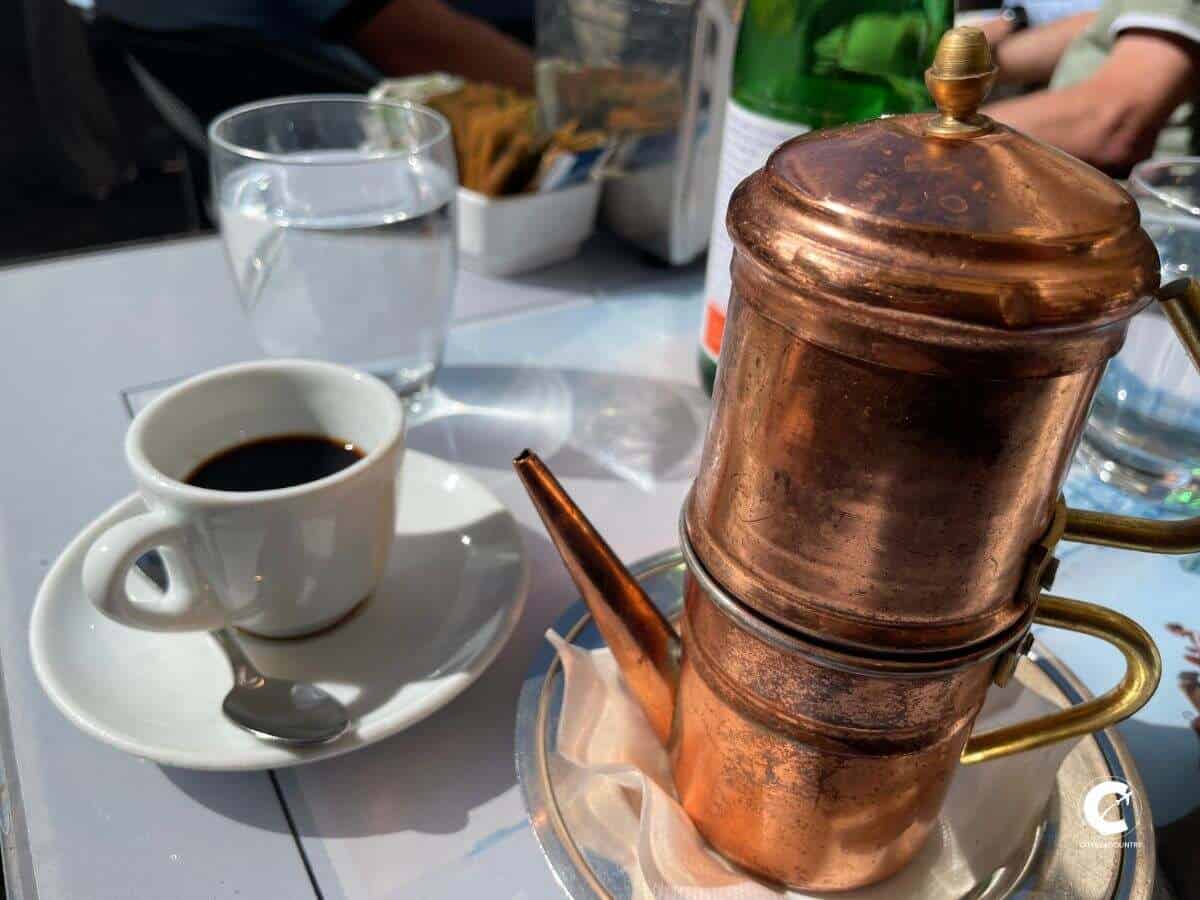 Spezieller Kaffee in Rom in Kupferkanne serviert mit einer Tasse Espresso