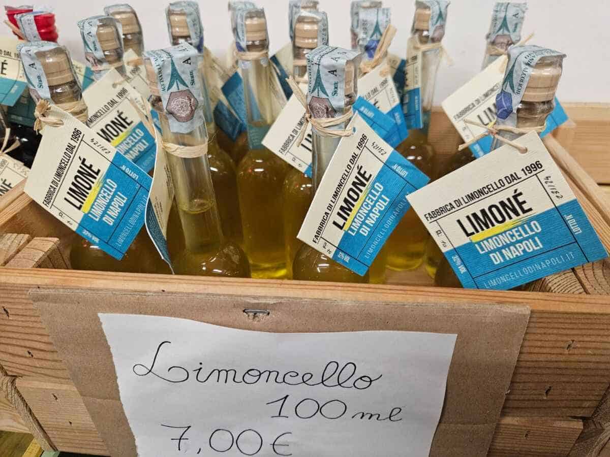 Holzkiste befüllt mit Limoncello-Flaschen und einem Schild mit der Beschriftung des Produkts in der einzigen Limoncello Herstellung in Neapel