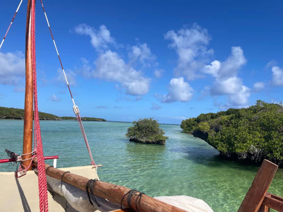 Blick vom traditionellen Holzboot auf kleine, bewaldete Felsen und seichtem Wasser auf dem Weg zur Blue Lagoon