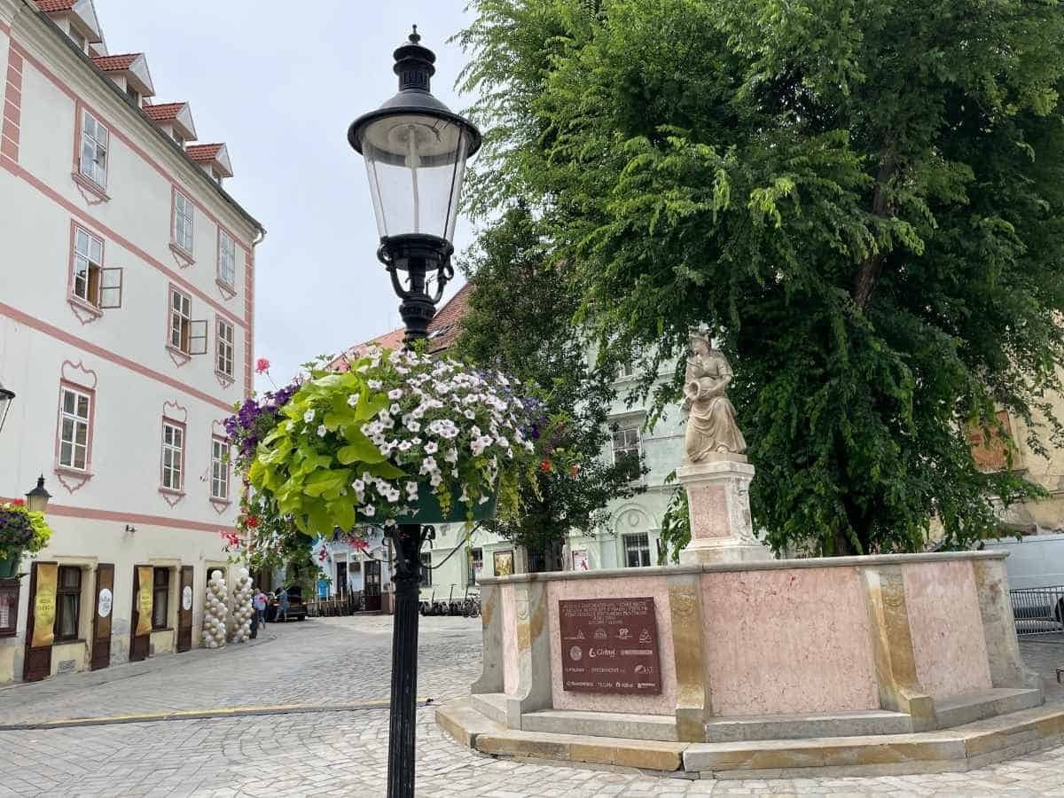Blick auf die Altstadt von Bratislava mit einer alten schwarzen Straßenlaterne und Steinbrunnen.