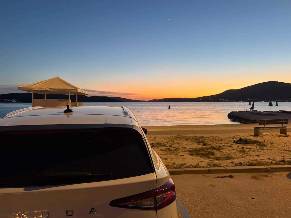 Auto am Parkplatz direkt am Meer bei Trogir in Kroatien bei Sonnenuntergang