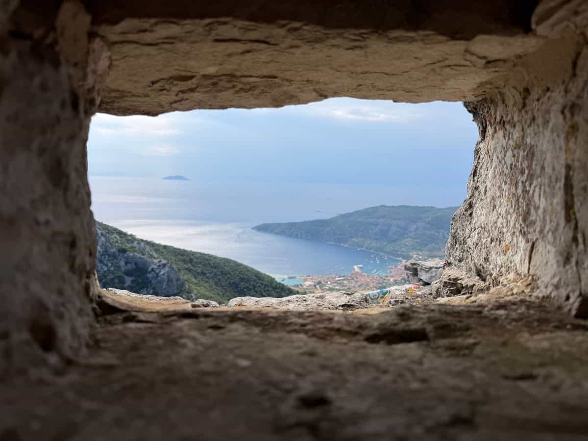 Blick durch ein Loch in einer Kirche hinunter auf Komiza in Vis
