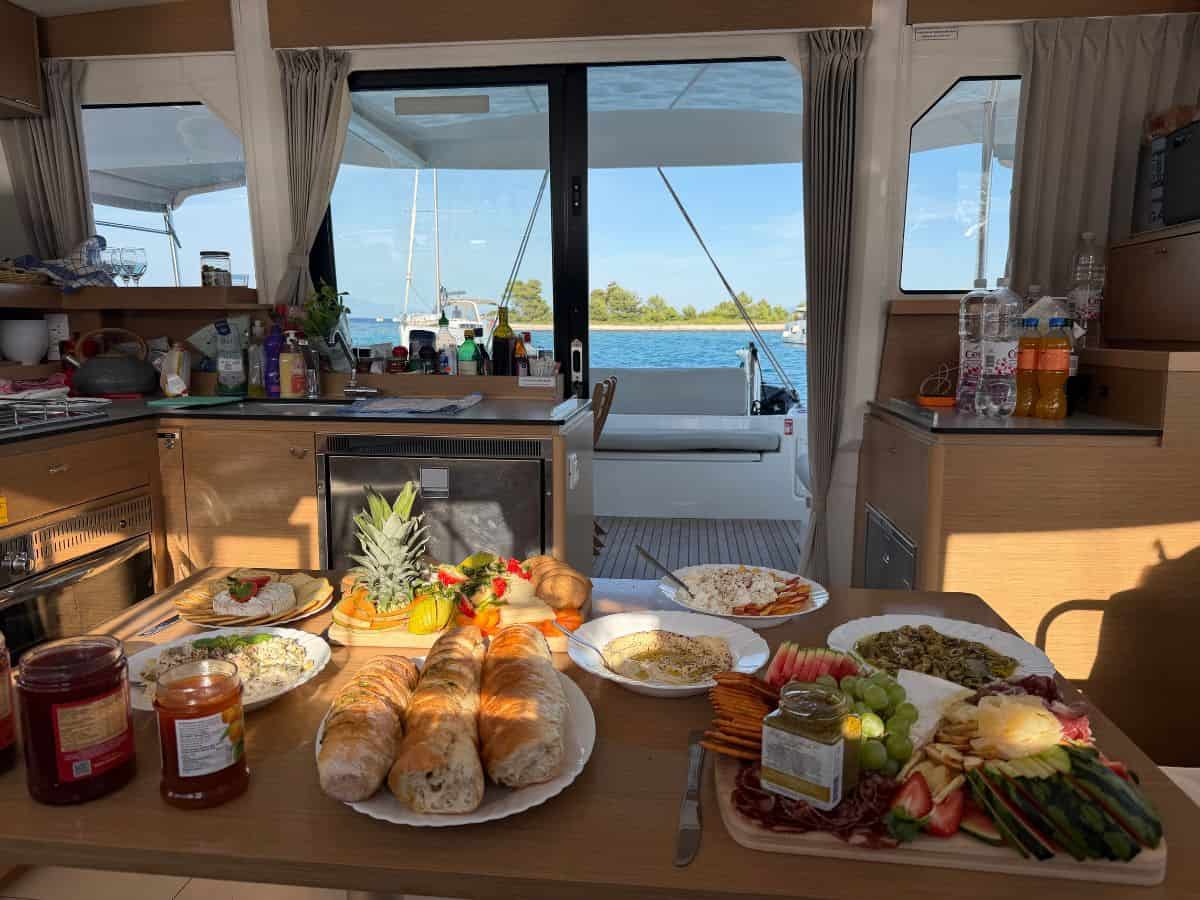 Frühstück-Buffet an Bord des Katamarans mit Meerblick und Insel im Hintergrund