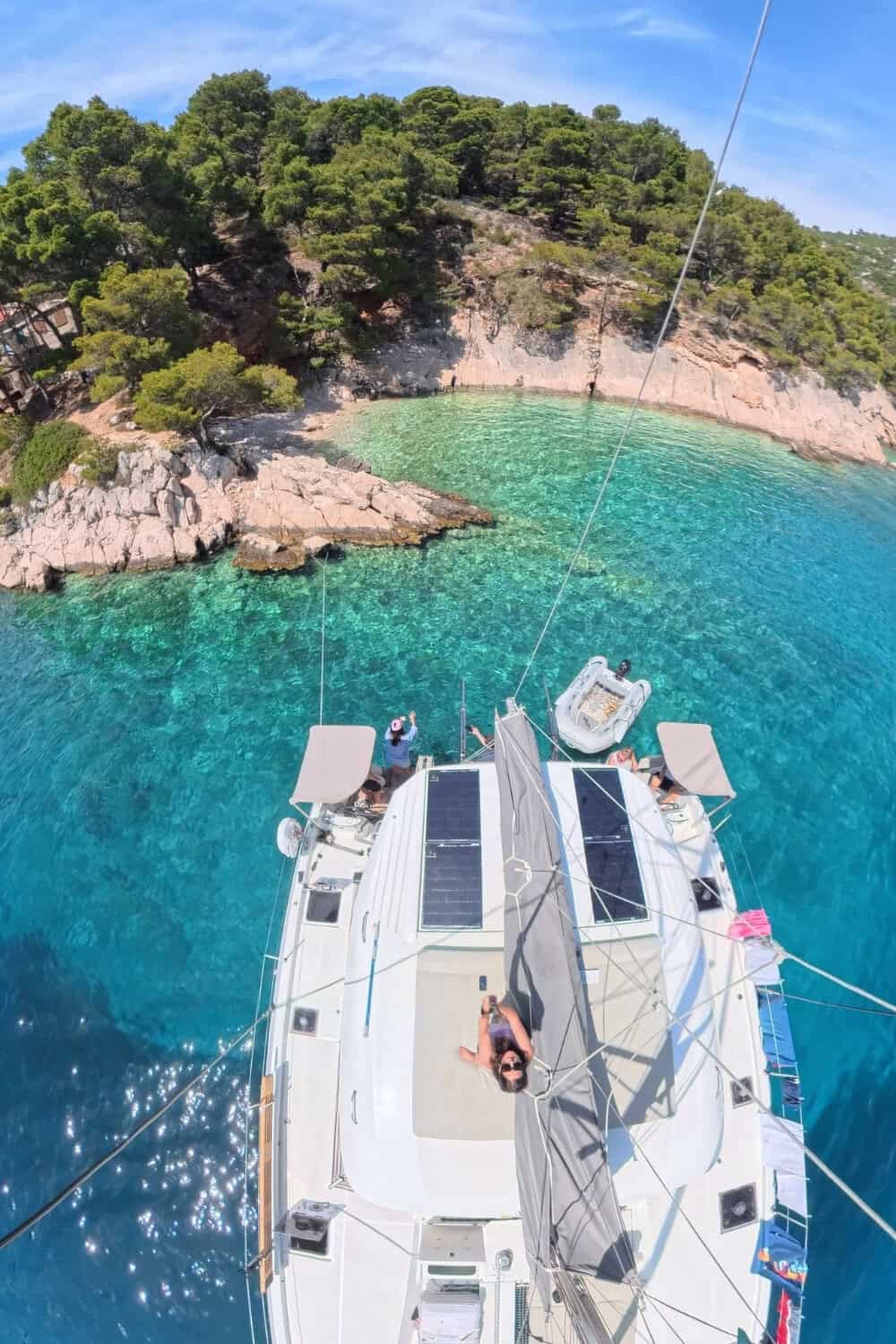 Drohnenähnliche Aufnahme ohne Drohne mit Katamaran und türkisfarbener Bucht von oben in Kroatien