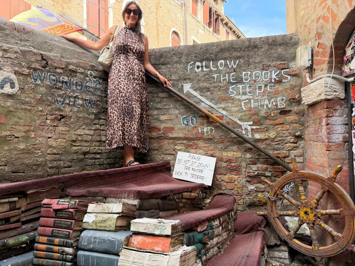 Christina auf der Bücherstufe der Livreria Acqua Alta in Venedig