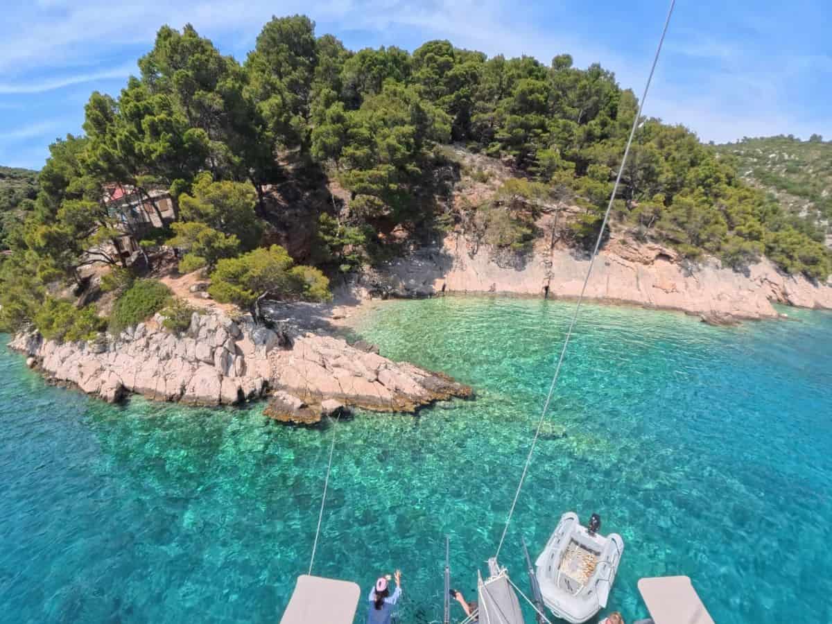 Katamaran von oben vor kleiner Bucht mit türkisfarbenem Wasser in Kroatien bei der Insel Šolta