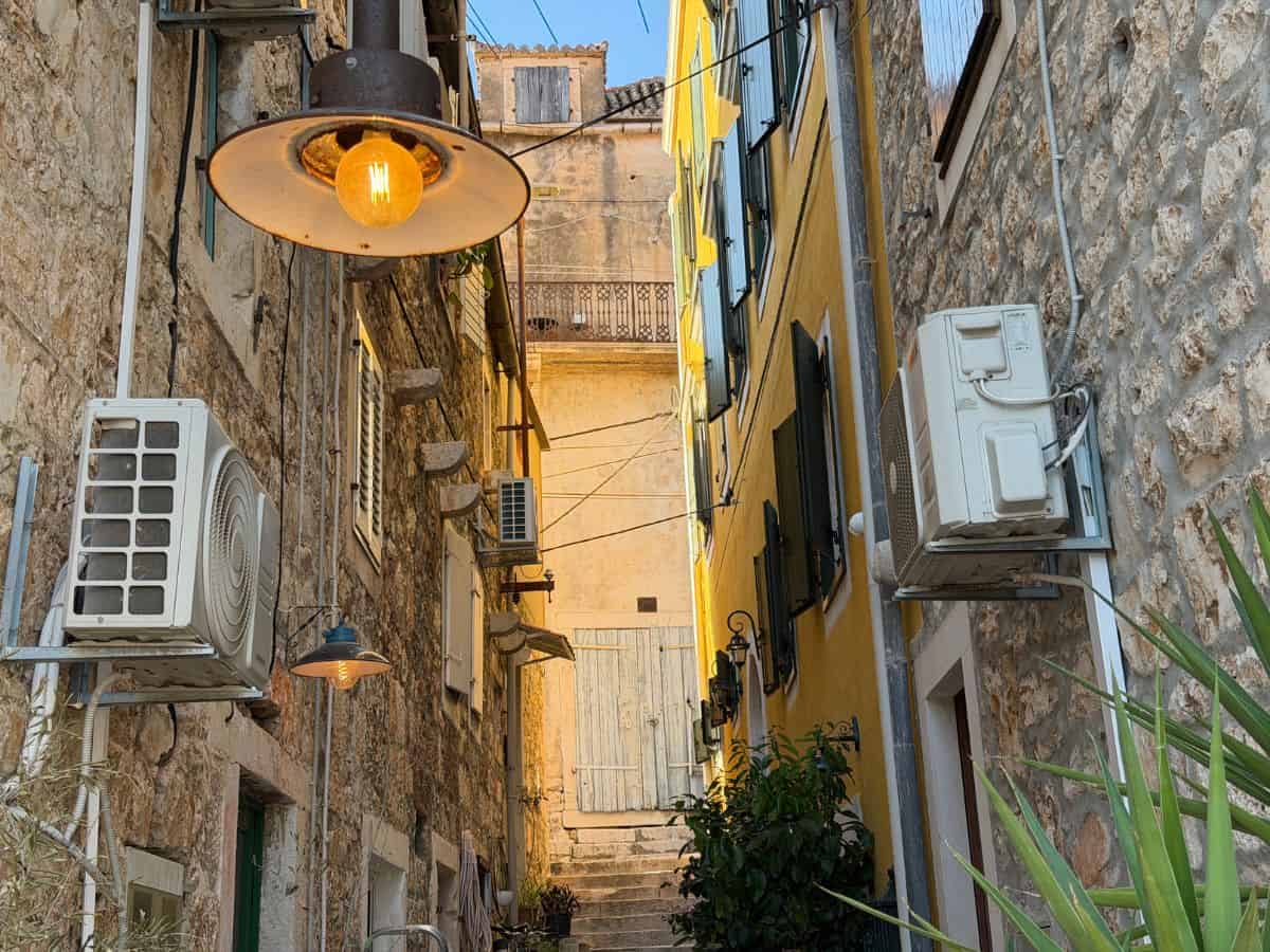 Gasse in Milna während der Golden Hour mit gelben Fassaden und Steinfassaden