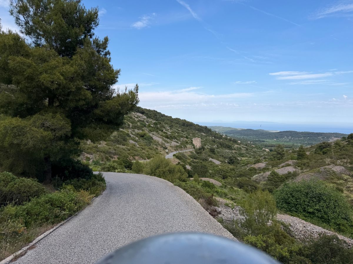 Blick auf den Motorradhelm und einer schmalen Straße auf der Insel Vis mit Blick auf das Meer hinunter