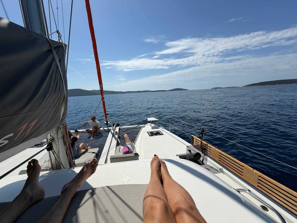 Deck des Katamarans mit Gästen die auf Liegen entspannen